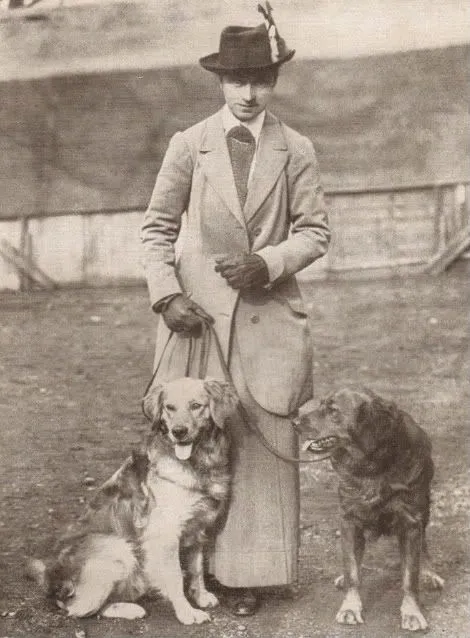 Gammalt fotografi av en kvinna och hennes två Golden Retriever-tikar, taget under 1910-talet